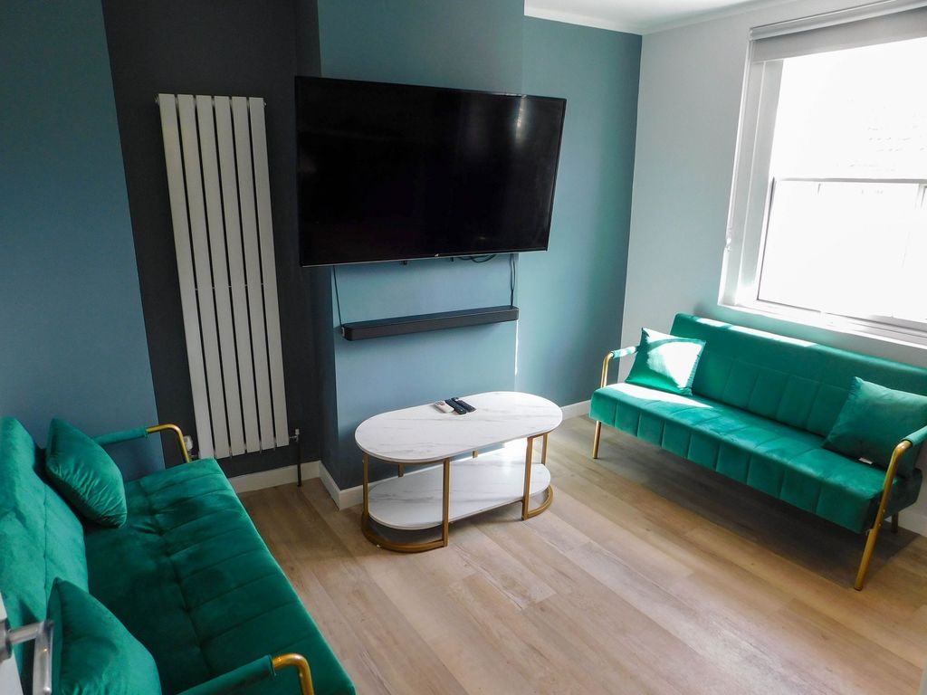 Property photo 2 of 4 Contemporary Living Room Featuring Two Vibrant Gre...