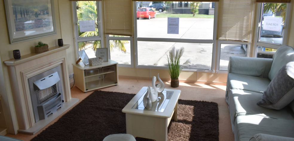 Property photo 2 of 9 Bright Front Living Area Of The Holiday Caravan With Large Windows, Feature Fireplace, Coffee Table And Comfortable Seating
