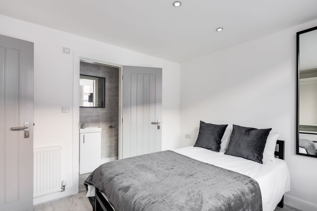 Property photo 3 of 11 A Modern, Well-Lit Bedroom Featuring A Large Doubl...