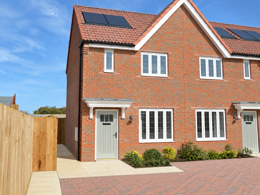 Property photo 1 of 8 A Two-Story Red Brick House With White-Framed Windows And Grey Doors Sits Behind A Paved Driveway An