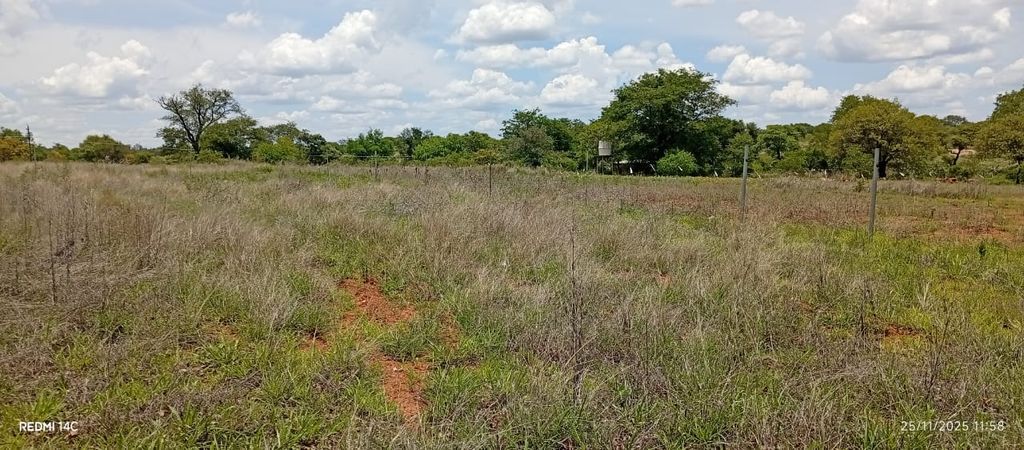 Property photo 2 of 9 Open Grassy Field With Dry Brown And Green Grass, A Fence Line, And Distant Trees Under A Partly Cloudy Sky.
