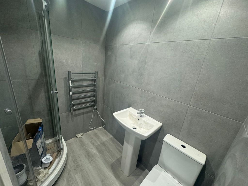 Property photo 2 of 4 A Modern Bathroom Featuring Sleek Grey Tiles, A Cu...