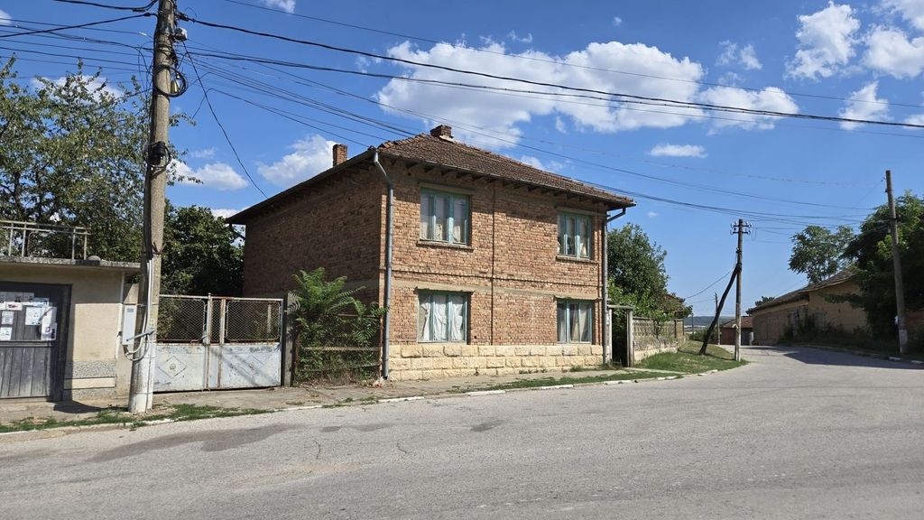 Property photo 2 of 56 Side View Of A Two-Storey Brick House With Green Window Frames And A Metal Gate Opening To The Street