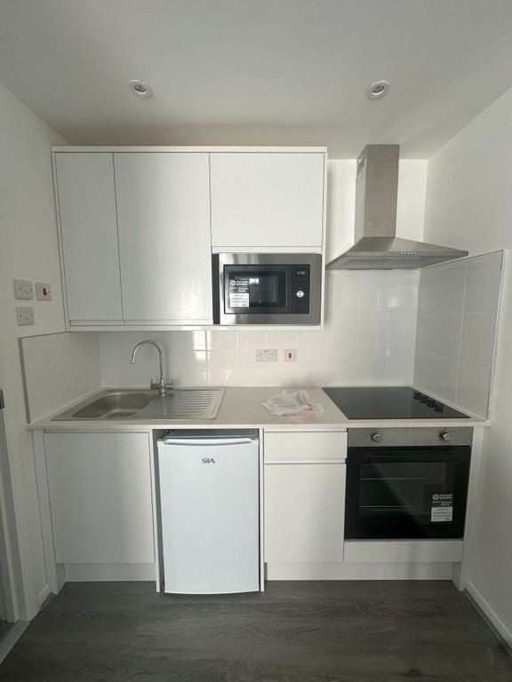 Property photo 3 of 7 Bright And Modern Kitchen Space Featuring Sleek Wh...