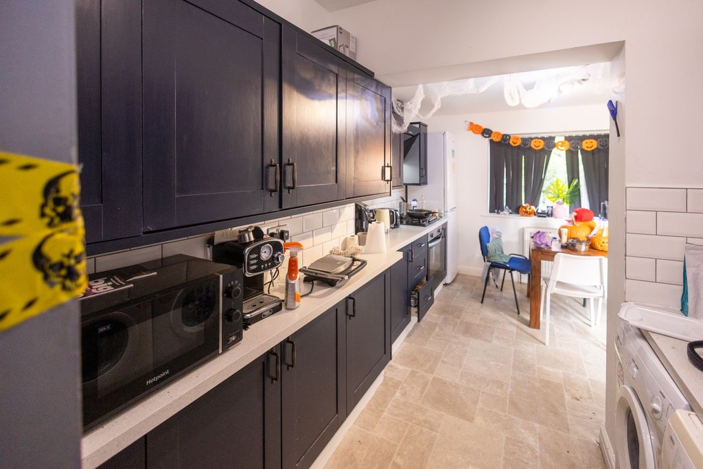 Property photo 1 of 6 A Modern Kitchen With Dark Cabinetry And A White c...