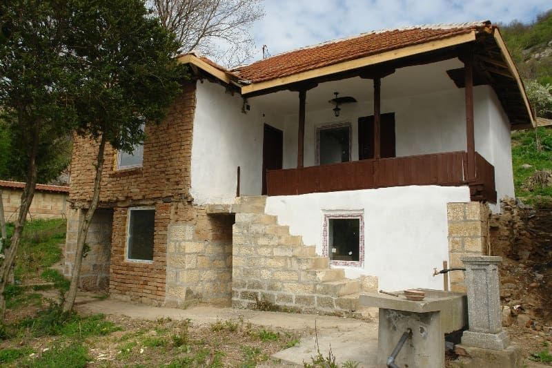 Property photo 3 of 54 Front And Side Angle Of The Rural House Highlighting Stone Stairs Leading To A Wooden Porch And Tiled Roof.