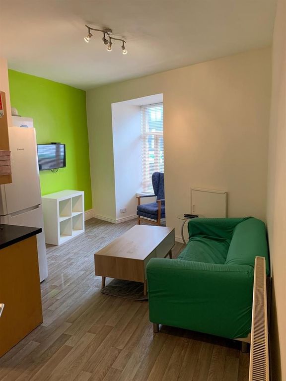 Property photo 2 of 9 A Cozy Living Room Featuring A Bright Green Sofa, ...