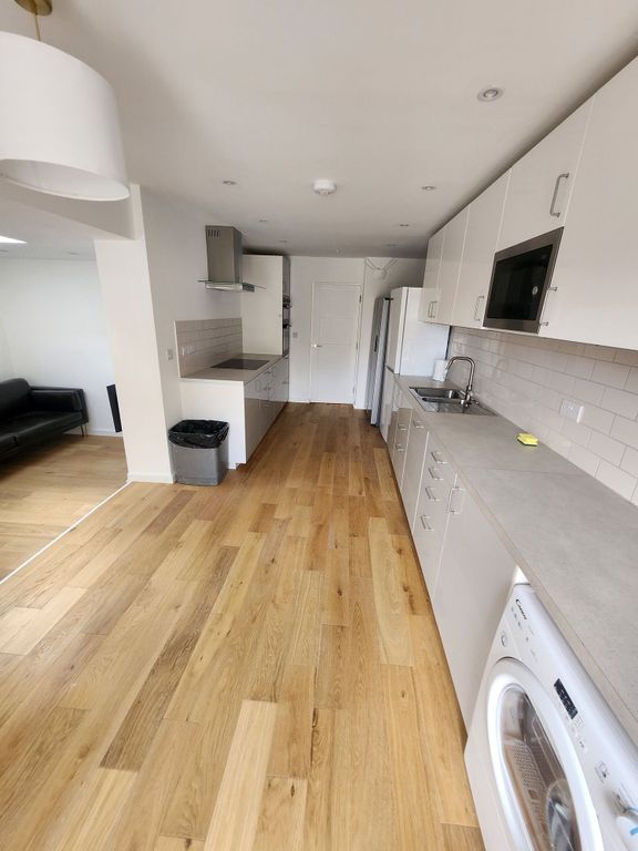Property photo 3 of 19 A Modern Kitchen Featuring Sleek White Cabinetry A...