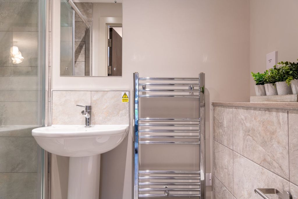 Property photo 2 of 4 A Modern Bathroom Featuring A Clean White Pedestal...