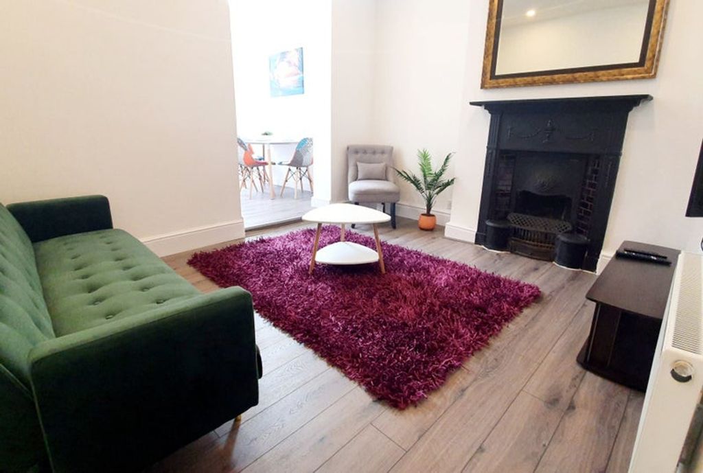 Property photo 2 of 10 A Stylish Living Room Featuring A Plush Green Sofa...