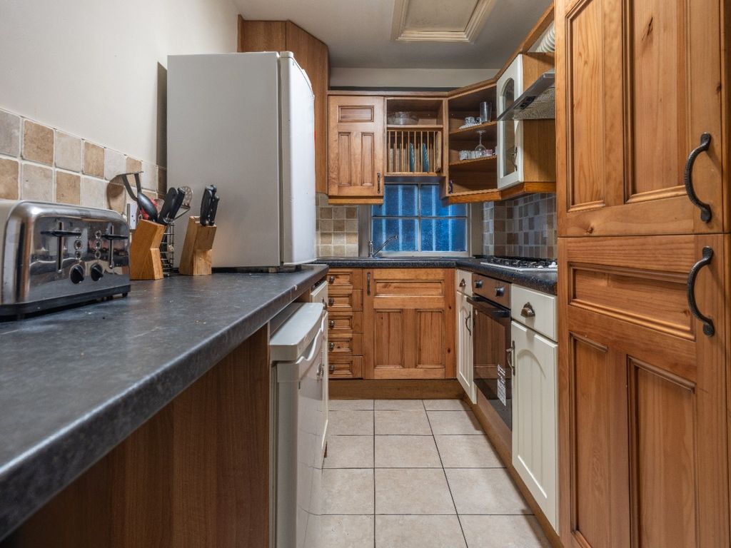 Property photo 2 of 7 A Warmly Lit Kitchen Featuring Wooden Cabinetry, A...