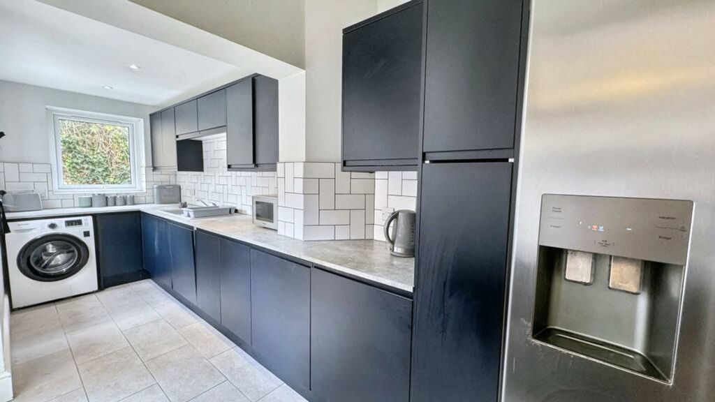 Property photo 2 of 11 A Modern And Spacious Kitchen Featuring Sleek Blac...