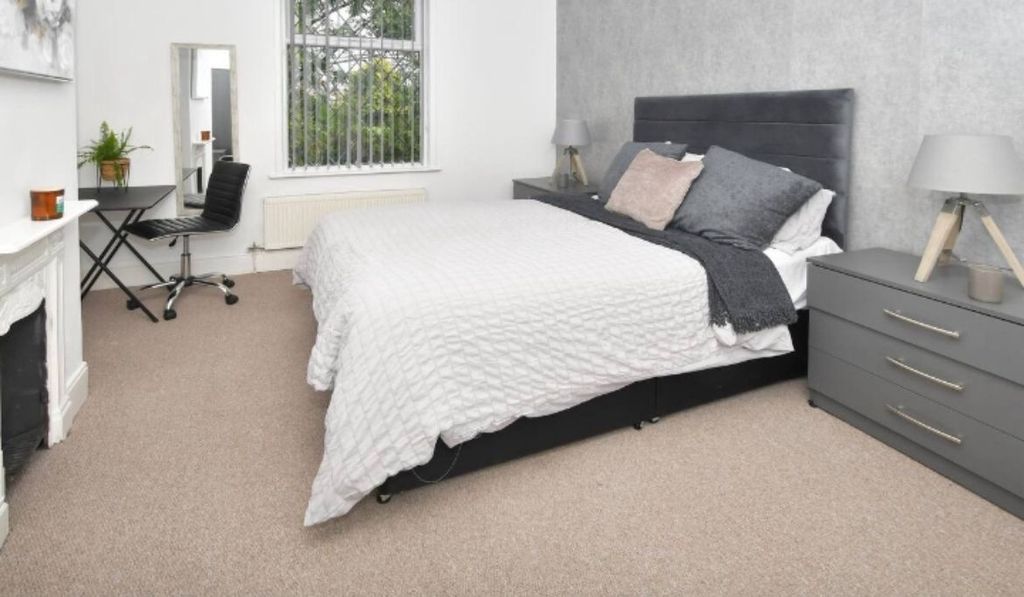 Property photo 2 of 14 A Modern, Well-Lit Bedroom Featuring A Large Bed W...