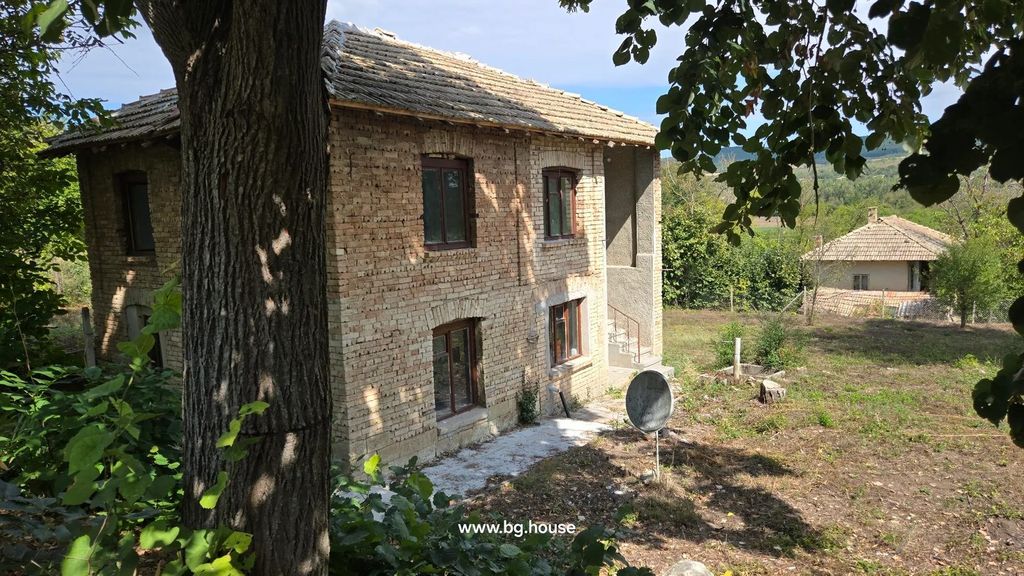 Property photo 1 of 43 Two-Story Brick House With Tiled Roof And Four Windows Visible, Surrounded By Trees And Greenery