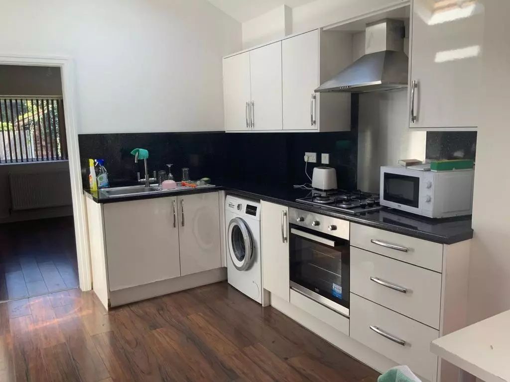 Property photo 3 of 6 Bright And Modern Kitchen Featuring Sleek Black Co...