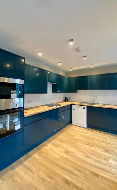 Property photo 1 of 20 Modern Kitchen Featuring Sleek Dark Blue Cabinetry...