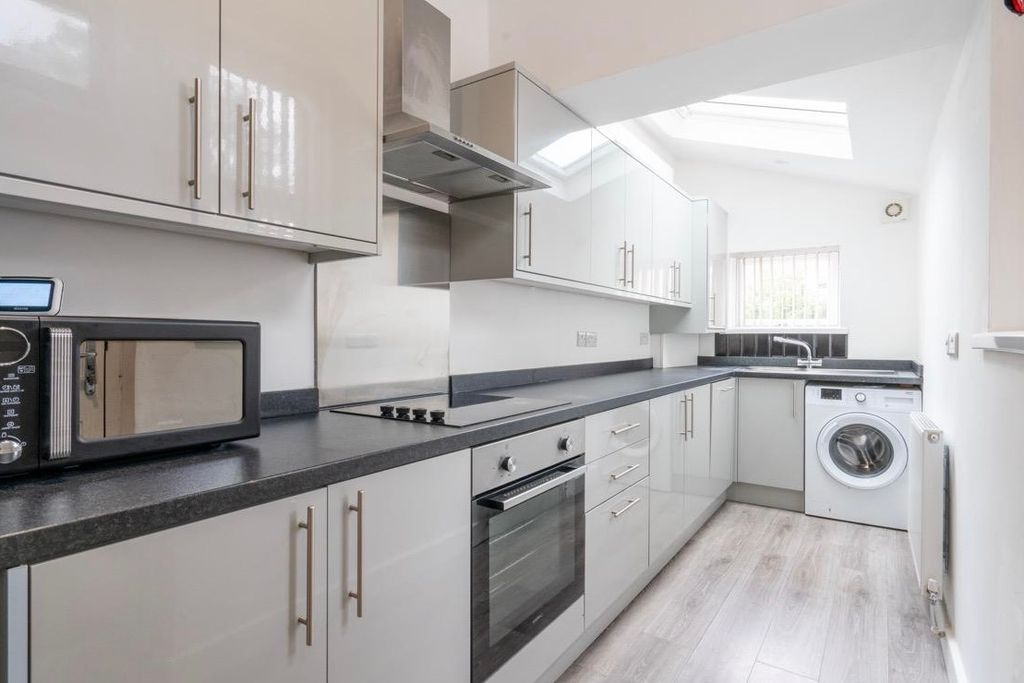 Property photo 3 of 6 Modern Galley Kitchen With Sleek White Cabinetry, ...