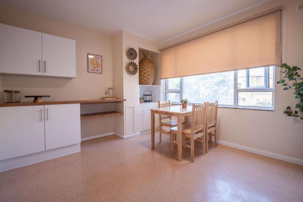 Property photo 3 of 13 A Bright Kitchen Area Featuring A Wooden Dining Ta...