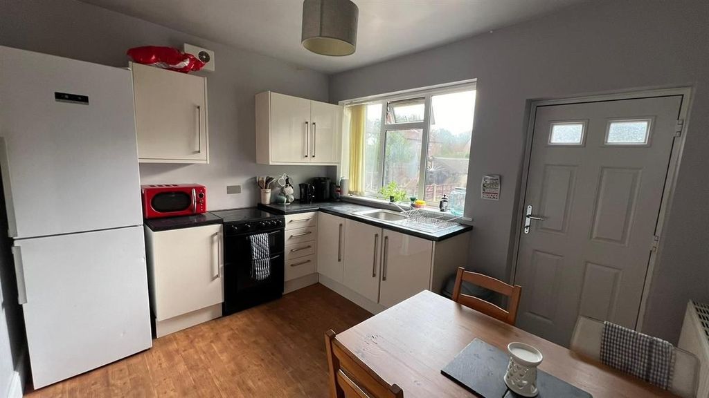 Property photo 3 of 12 A Well-Lit Kitchen Area With White Cabinets, A Win...