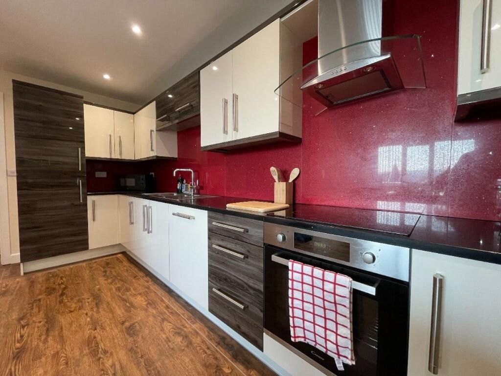 Property photo 3 of 13 Modern Kitchen With Sleek Cabinetry, A Vibrant Red...