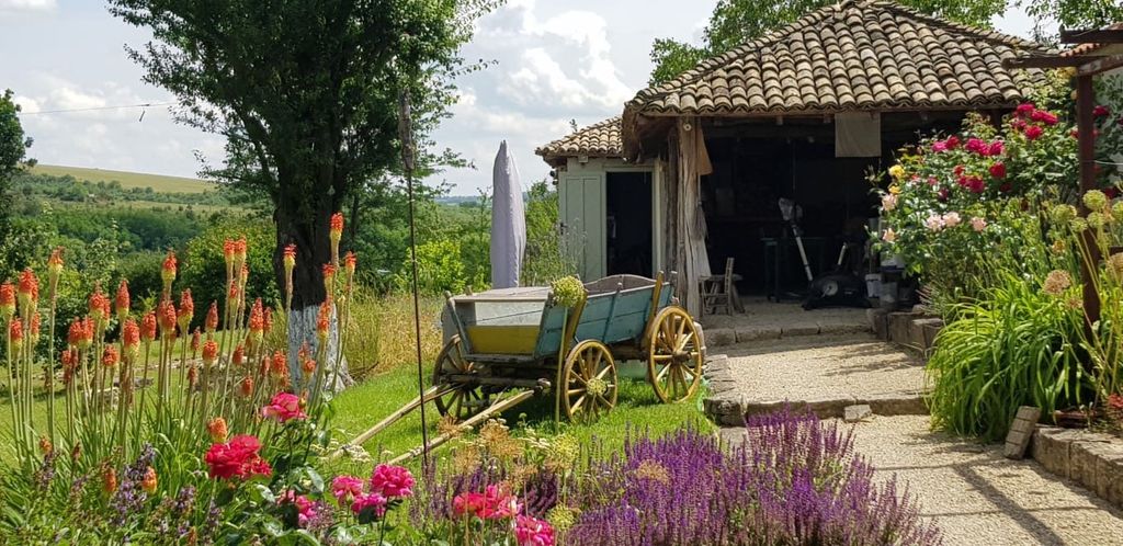 Property photo 2 of 100 Rustic Outbuilding With Tiled Roof Next To Vibrant Garden Flowers And Green Trees