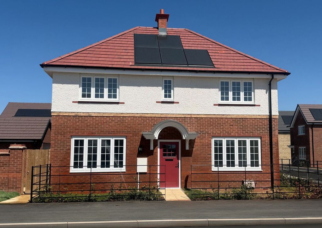 Property photo 1 of 8 A Modern Two-Story House With A Red-Tiled Roof And Solar Panels Sits Behind A Black Metal Fence