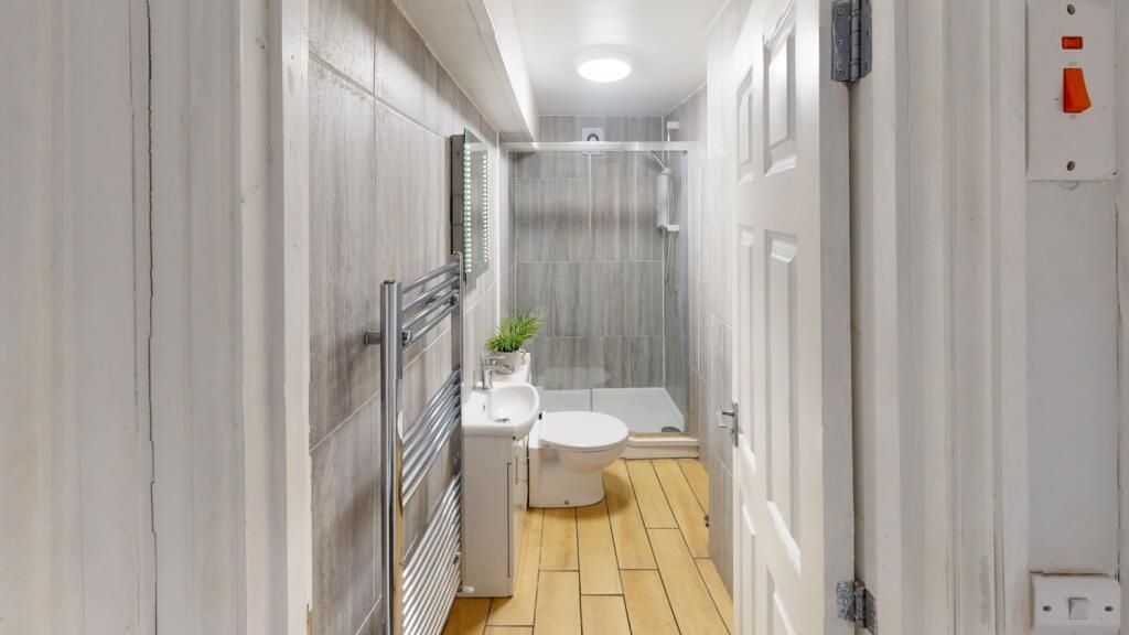 Property photo 3 of 11 A Modern Bathroom Featuring A White Toilet And A S...