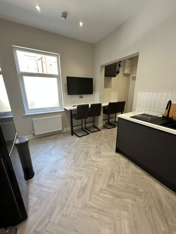 Property photo 1 of 7 Modern Kitchen Area Featuring A Stylish Black-And-...