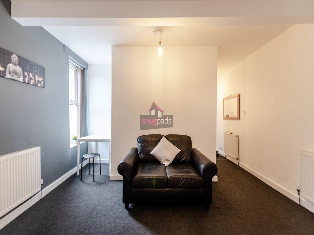 Property photo 1 of 6 A Cozy Living Room Featuring A Comfortable Black A...
