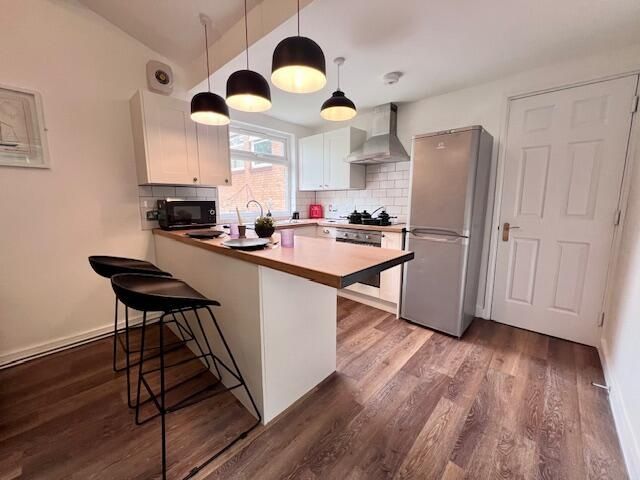 Property photo 3 of 9 A Modern Kitchen Featuring A Large Central Island ...