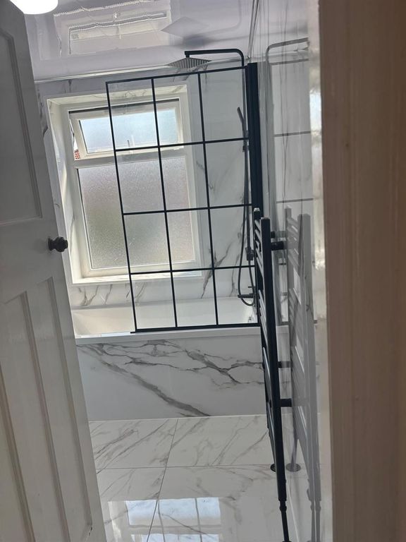 Property photo 1 of 8 Elegant Marble Bathroom With Stylish Black Accents...