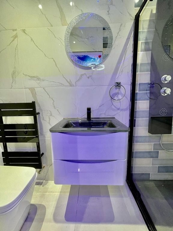 Property photo 3 of 12 A Modern Bathroom Featuring Sleek White Marble-Eff...