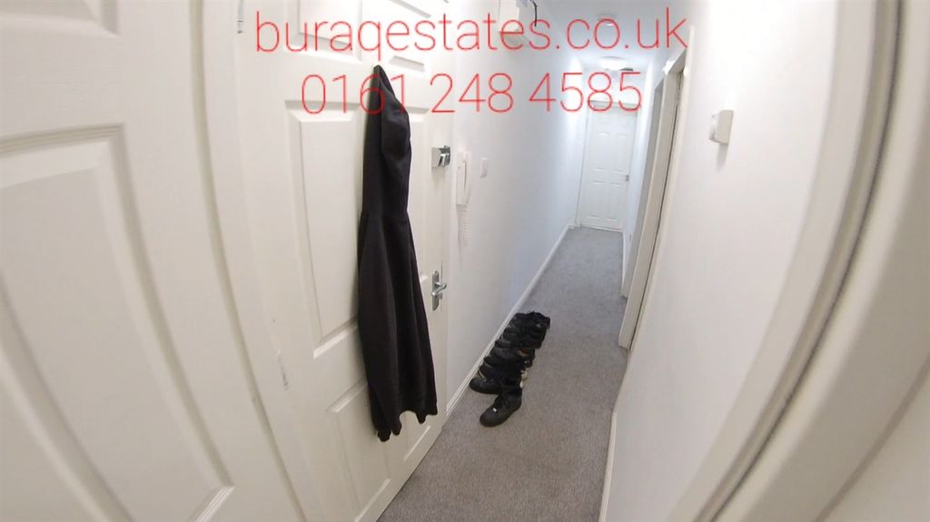 Property photo 1 of 6 Narrow Carpeted Hallway With White Doors And Neutr...