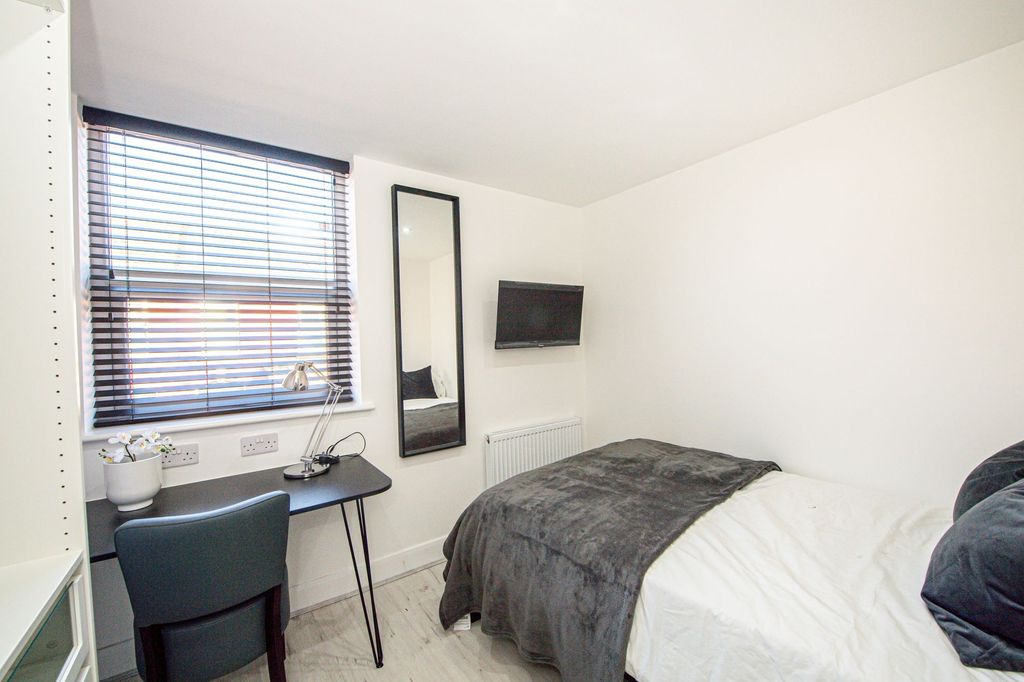 Property photo 3 of 7 A Modern, Well-Lit Bedroom Featuring A Comfortable...