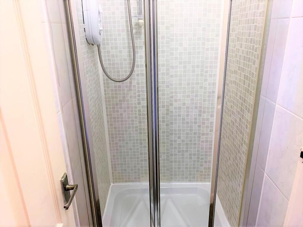 Property photo 1 of 12 A Modern Bathroom Featuring A Sleek Shower Enclosu...