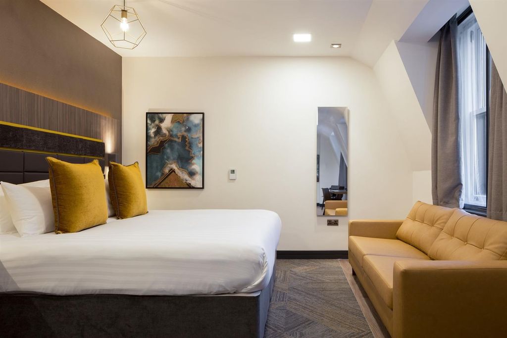 Property photo 1 of 10 Elegant Bedroom With Plush Bed And Seating Area...