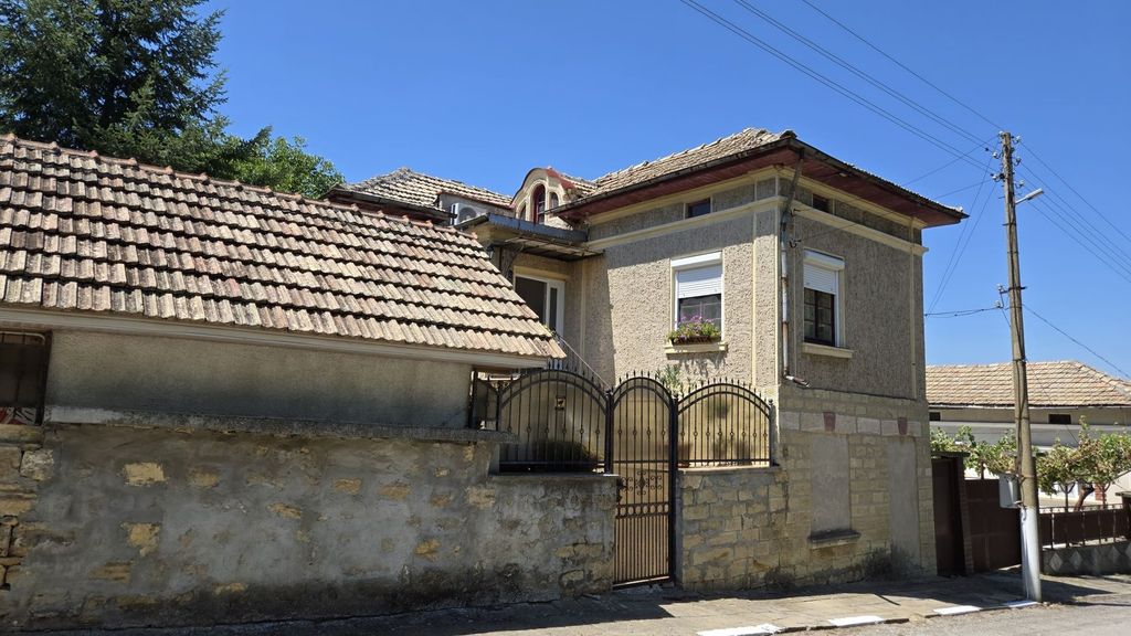 Property photo 2 of 100 Side Perspective Of The Bulgarian House Highlighting The Tiled Roof And Stone Wall With A Metal Gate.