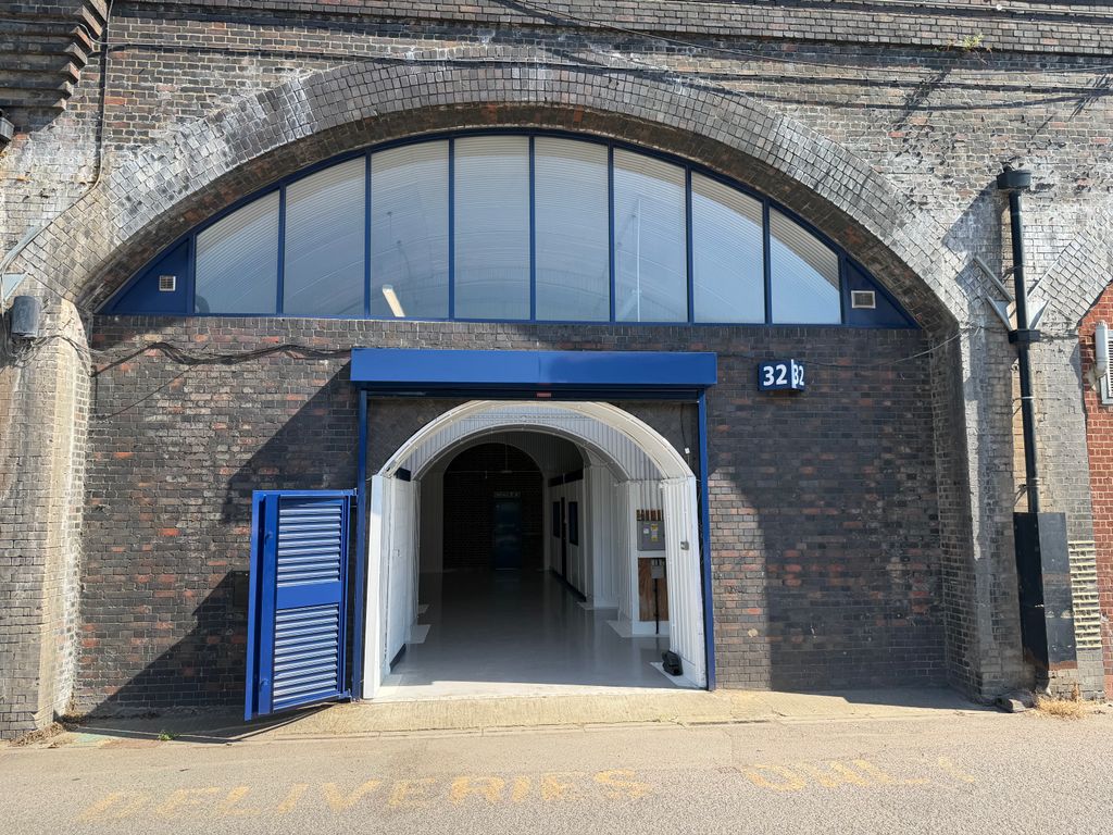 Property photo 1 of 3 The Front Of An Arch, With High Level Glazing, An Open Electric Roller Shutter Entrance Big Enough For Vehicle Access, And A Pedestrian Door.