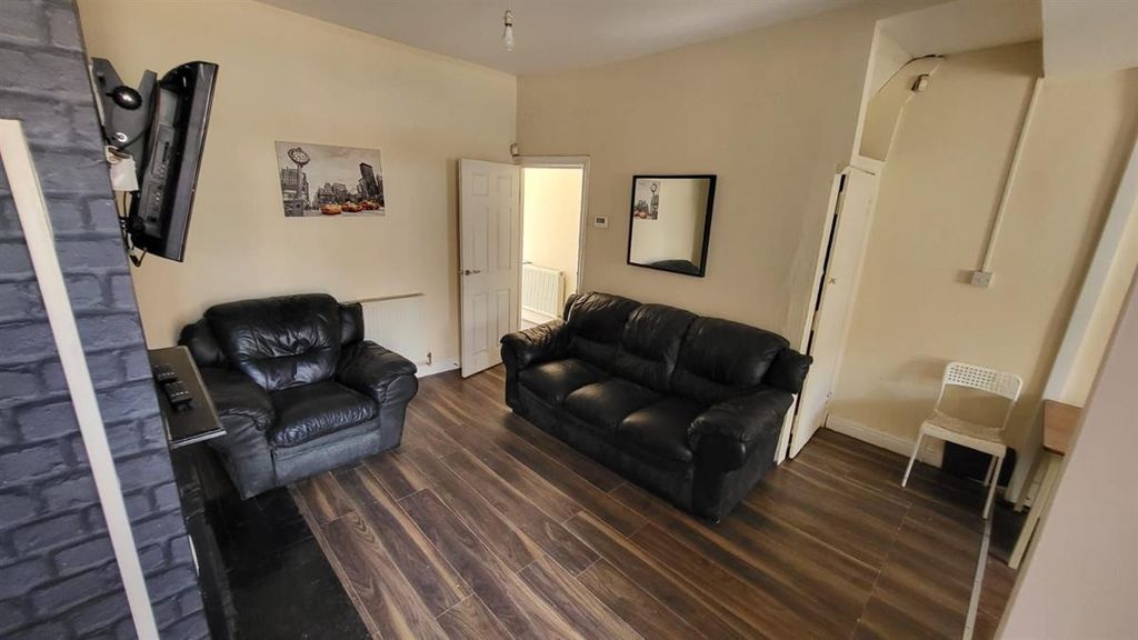 Property photo 3 of 12 A Modern Living Room Featuring Two Comfortable Bla...