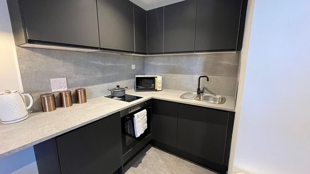 Property photo 3 of 10 A Sleek Modern Kitchen With Dark Matte Cabinets An...