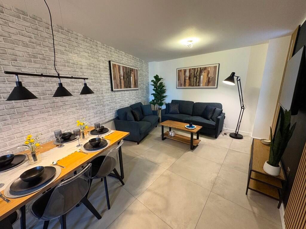 Property photo 3 of 12 A Modern And Inviting Living Room Featuring A Comf...