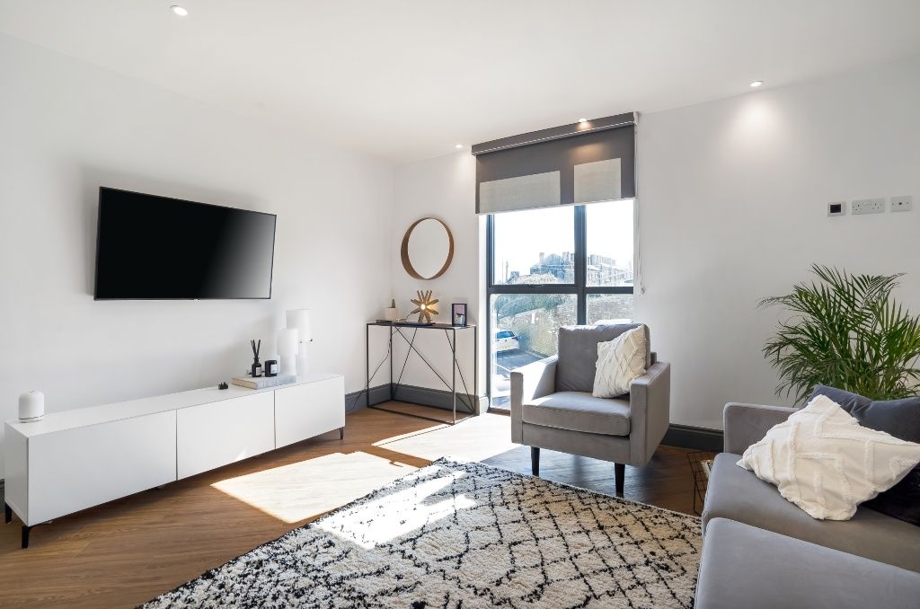 Property photo 1 of 7 Bright And Modern Living Room Featuring A Large Wi...