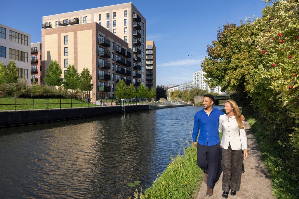 Property photo 2 of 7 Two People Walking Down The Canal With Their Arms Around Each Other And The Apartments In The Distan