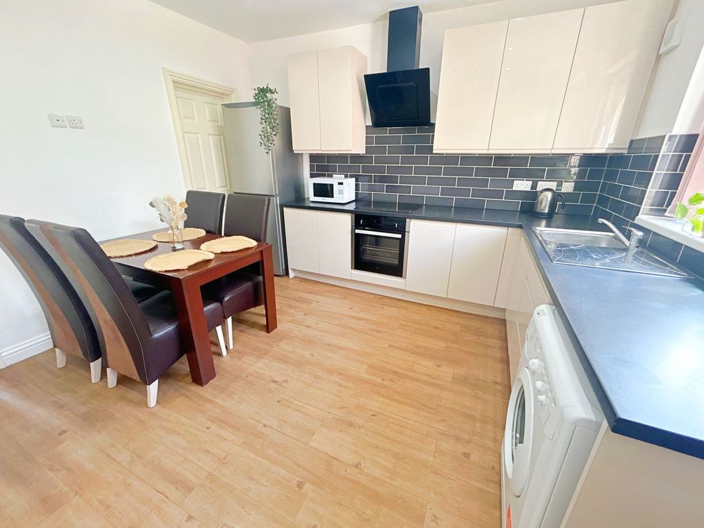Property photo 3 of 8 Bright And Modern Kitchen Featuring A Sleek Black ...