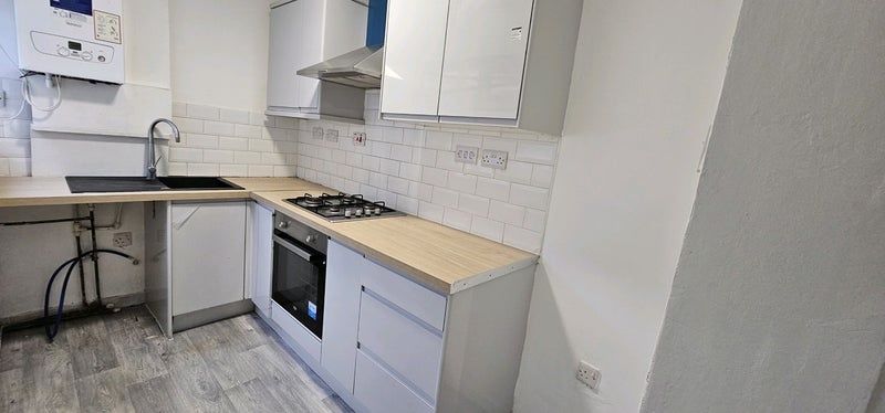 Property photo 3 of 6 Modern Kitchen With Sleek White Cabinets, Wood-Ton...