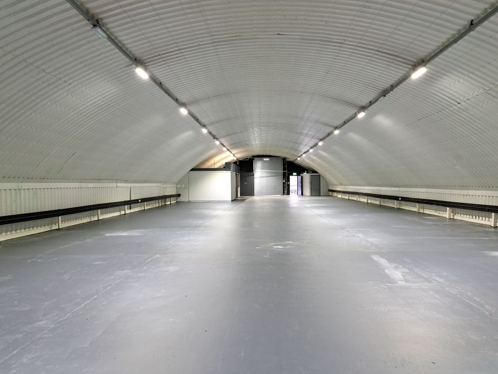 Property photo 2 of 6 An Empty Arch With White Lining, Facing The Front Electric Roller Shutter Entrance, Which Is Closed. There Is A WC Cubicle At The Front Of The Arch.