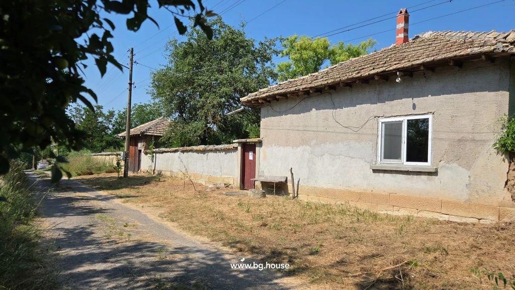 Property photo 2 of 100 Side Perspective Of The House With Visible Window, Bench, Wooden Door In The Wall, And Dirt Path.