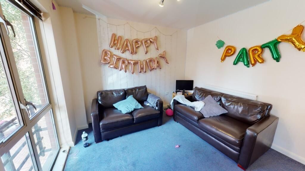 Property photo 2 of 5 A Cheerful Living Room Featuring Two Dark Leather ...