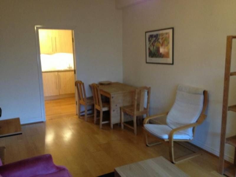 Property photo 3 of 10 A Cozy Living Room Featuring A Wooden Dining Table...