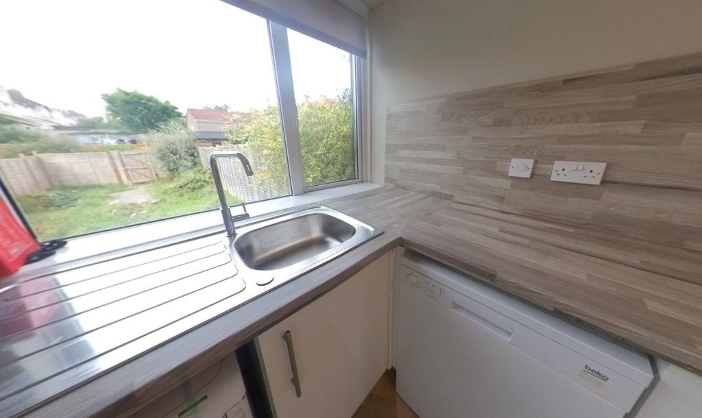 Property photo 3 of 12 Bright Galley-Style Kitchen With A Large Window Of...